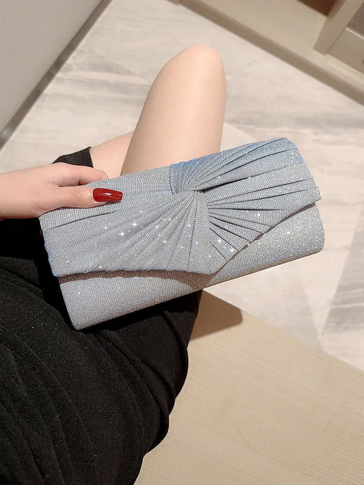 Horizontal square dinner clutch in silver or gold with woven exterior, open pocket, and internal phone bag.