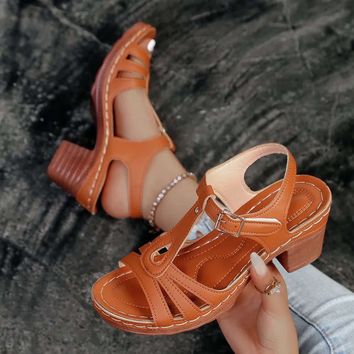 Women's black peep toe wedge platform sandals with a buckle fastening on a grey background
