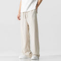 Man wearing beige bamboo fibre cropped trousers with a drawstring waist and straight legs.