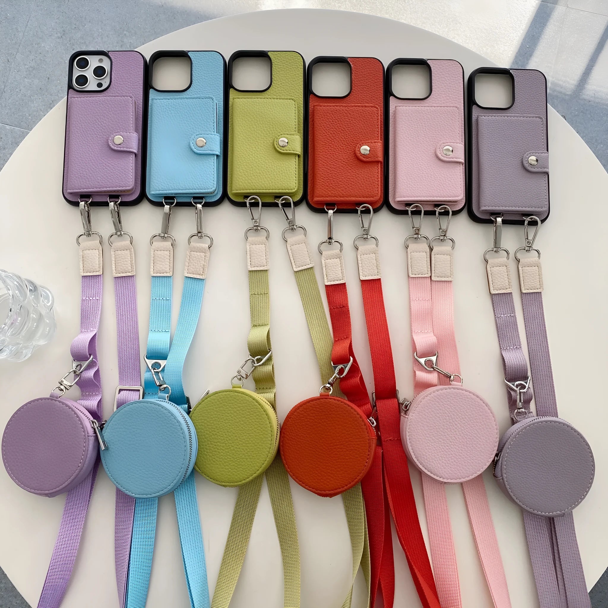 Polycarbonate leather lanyard phone case with card slot for iPhone, shown in black, brown, orange and white.