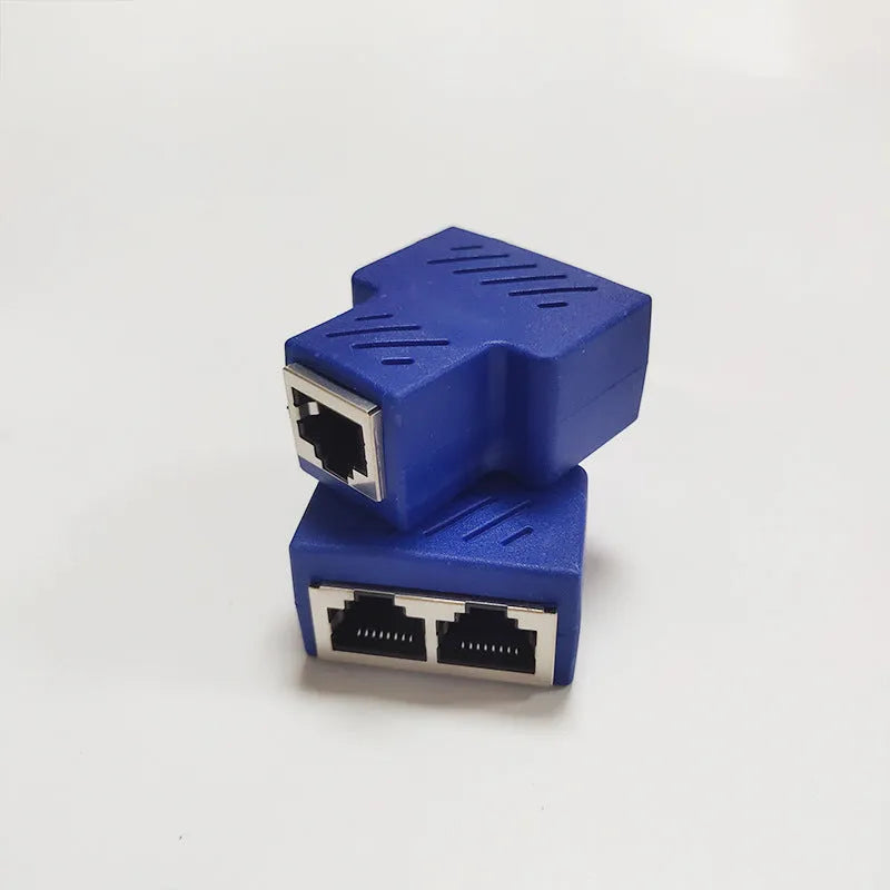 Two white RJ45 three-way tee network cable splitters on a dark surface.