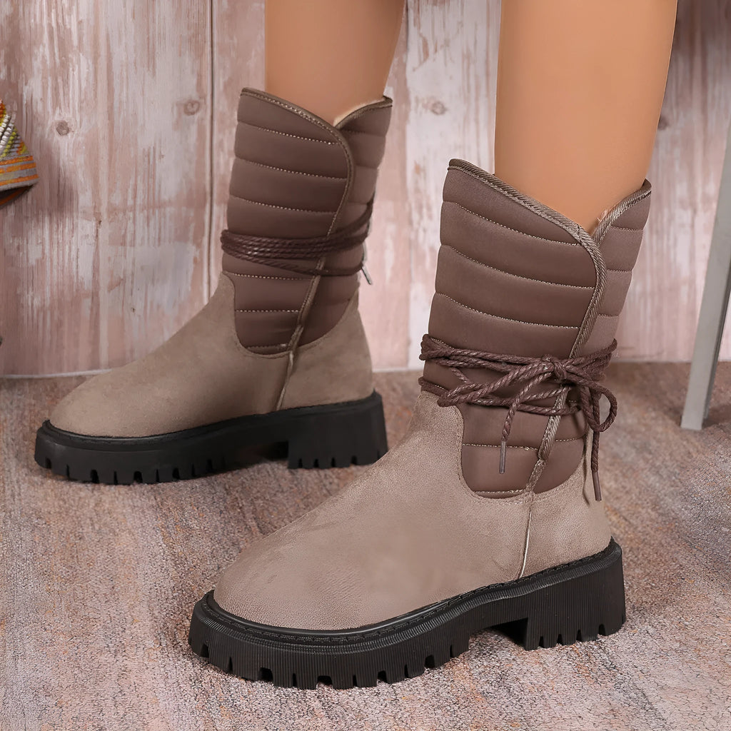 Black women's high-top snow boots with a chunky heel and lace-up front on a grey background.
