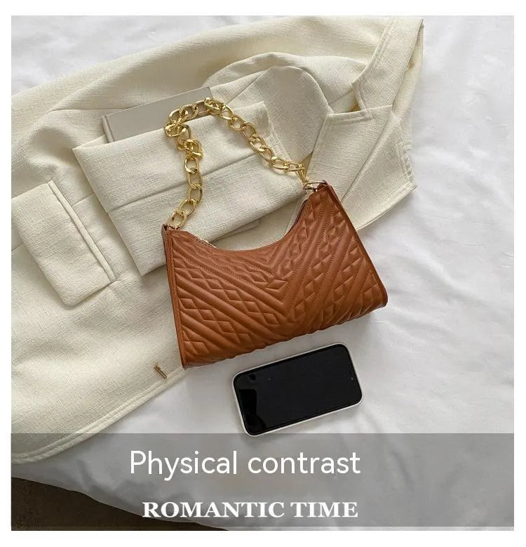 A structured black pleated women's shoulder bag with a chain strap and a soft handle, showing its square shape.