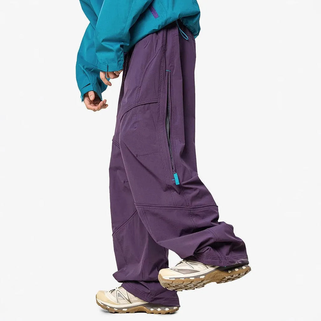 Men's waterproof loose casual pants in Graphite Black for outdoor use, side view on mountain trail