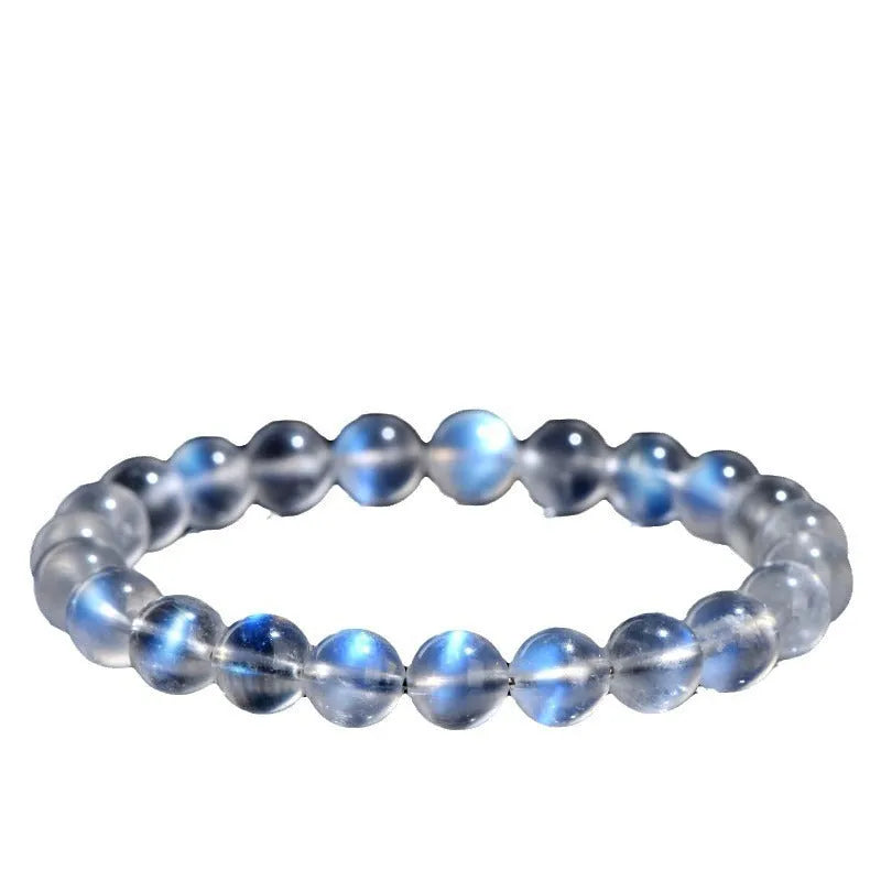 Polished natural cream body blue moonlight crystal bracelet on a wrist, showing simple bead design.