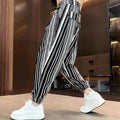 Men's cropped ankle-tied ice silk pants in dark gray stripe pattern, front view on model
