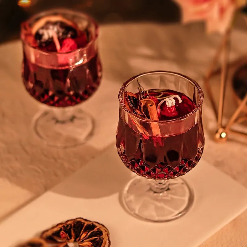 Glass wine goblet shaped container holding a French mulled wine scented aromatherapy candle.
