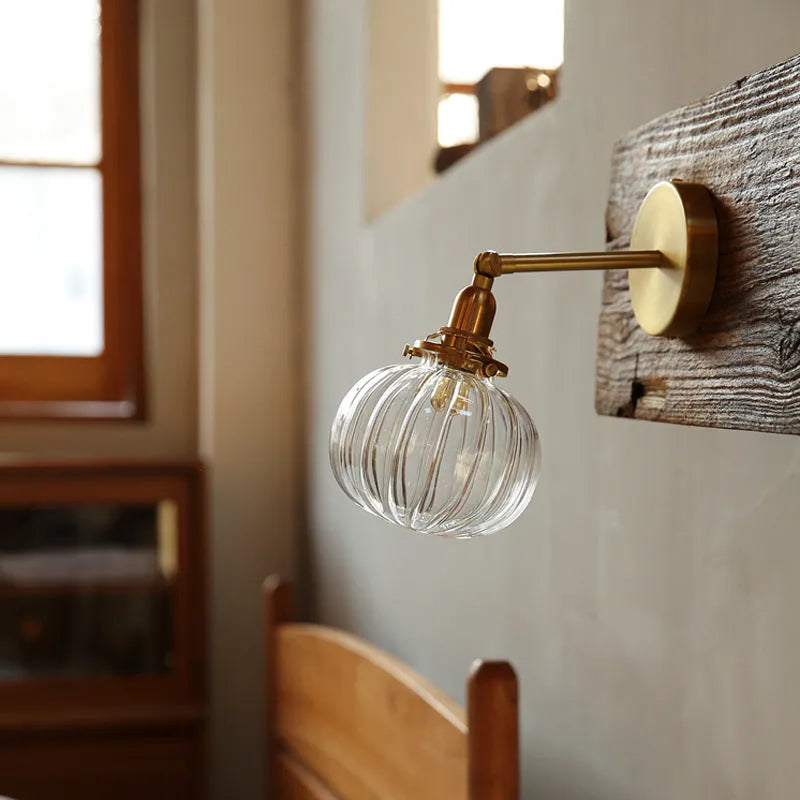 Creative pumpkin-shaped wall lamp with a textured water ripple glass shade mounted on a white wall