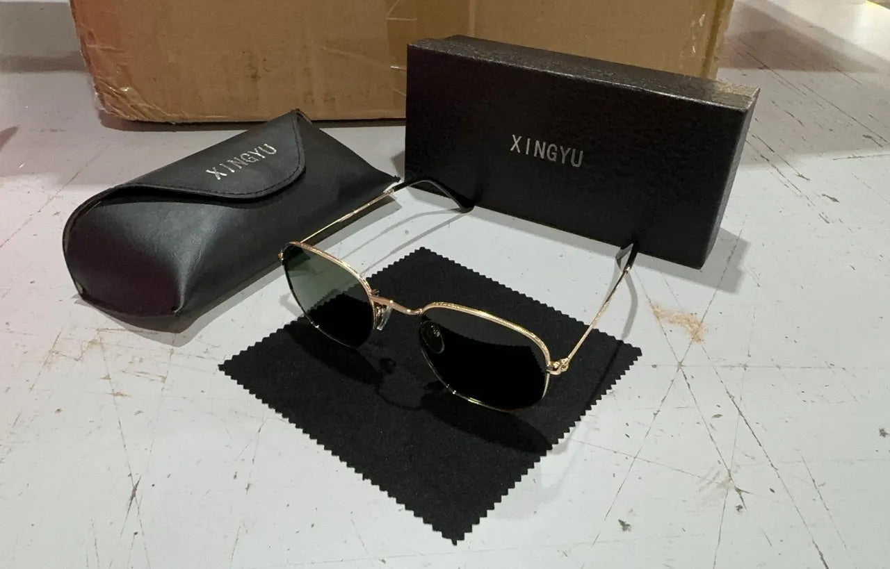 Classic round metal frame sunglasses for men in gun grey colour with UV400 lenses on a table.