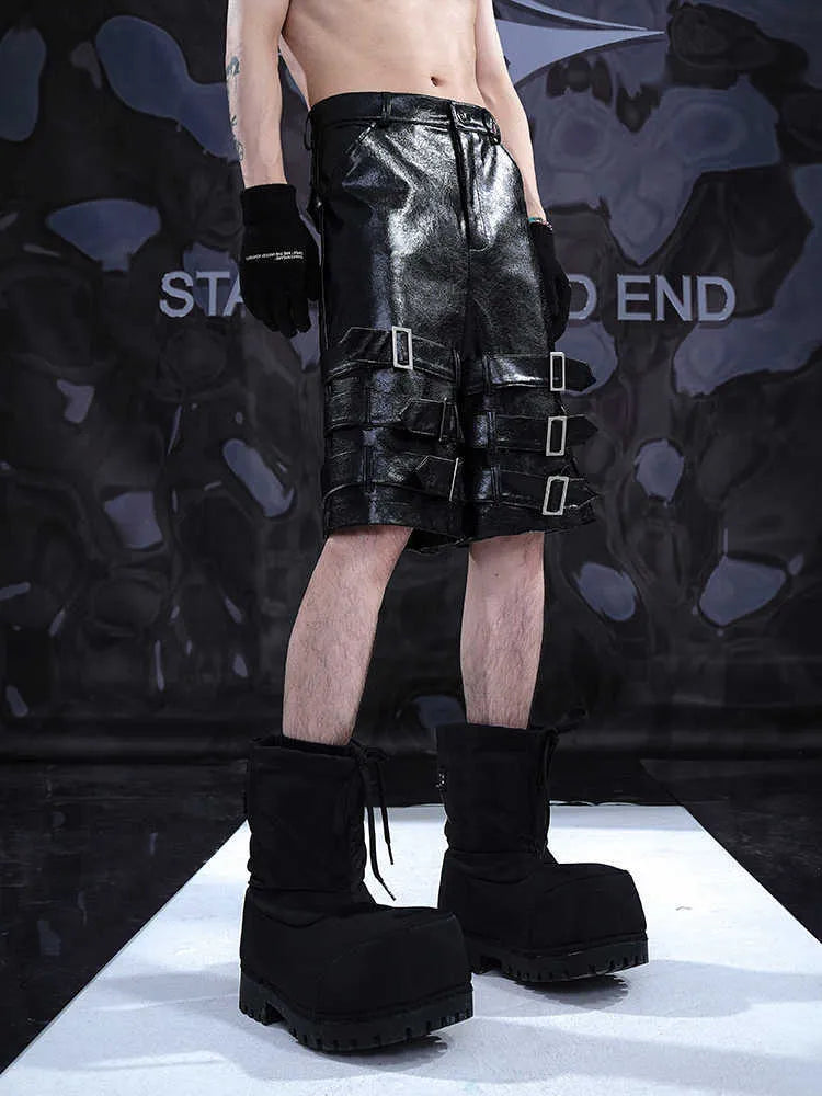 Men's black PU leather cropped pants with a ring detail on low-waist shorts.