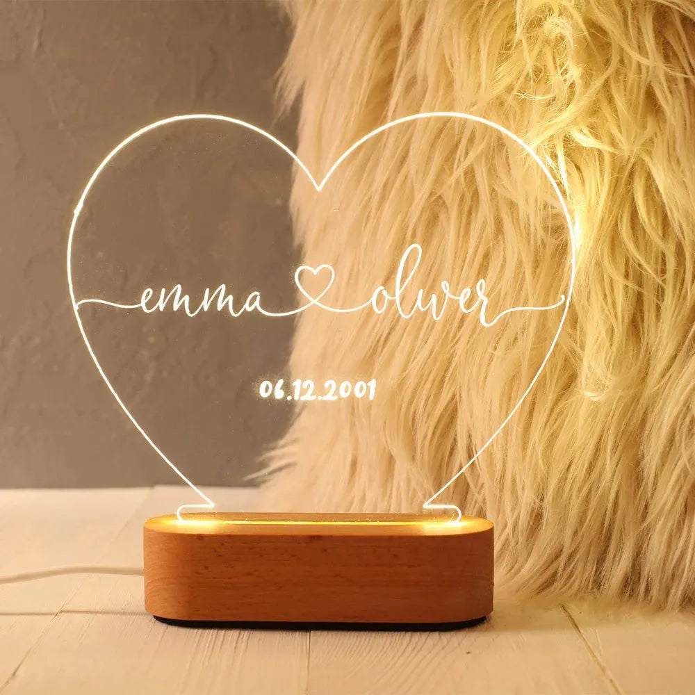 Custom clear acrylic night light displaying personalised names and date, lit by an LED base.