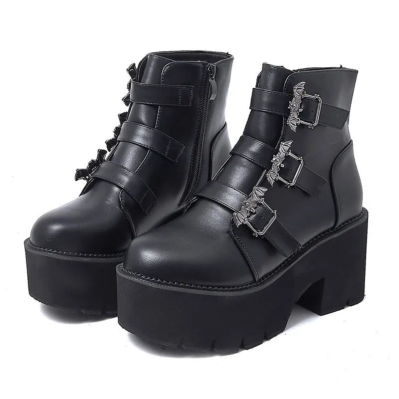 Black women's punk ankle boots with metal bat buckle and thick platform sole.