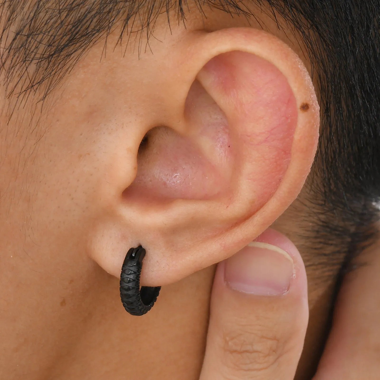 A pair of men's stainless steel earrings featuring a black snake pattern design, shown front-on.