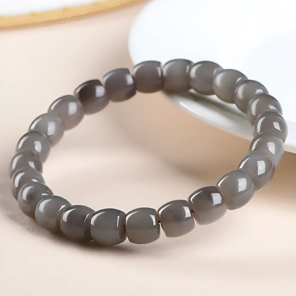 Natural smokey violet Hetian jade straight cut bead bracelet on a wrist.
