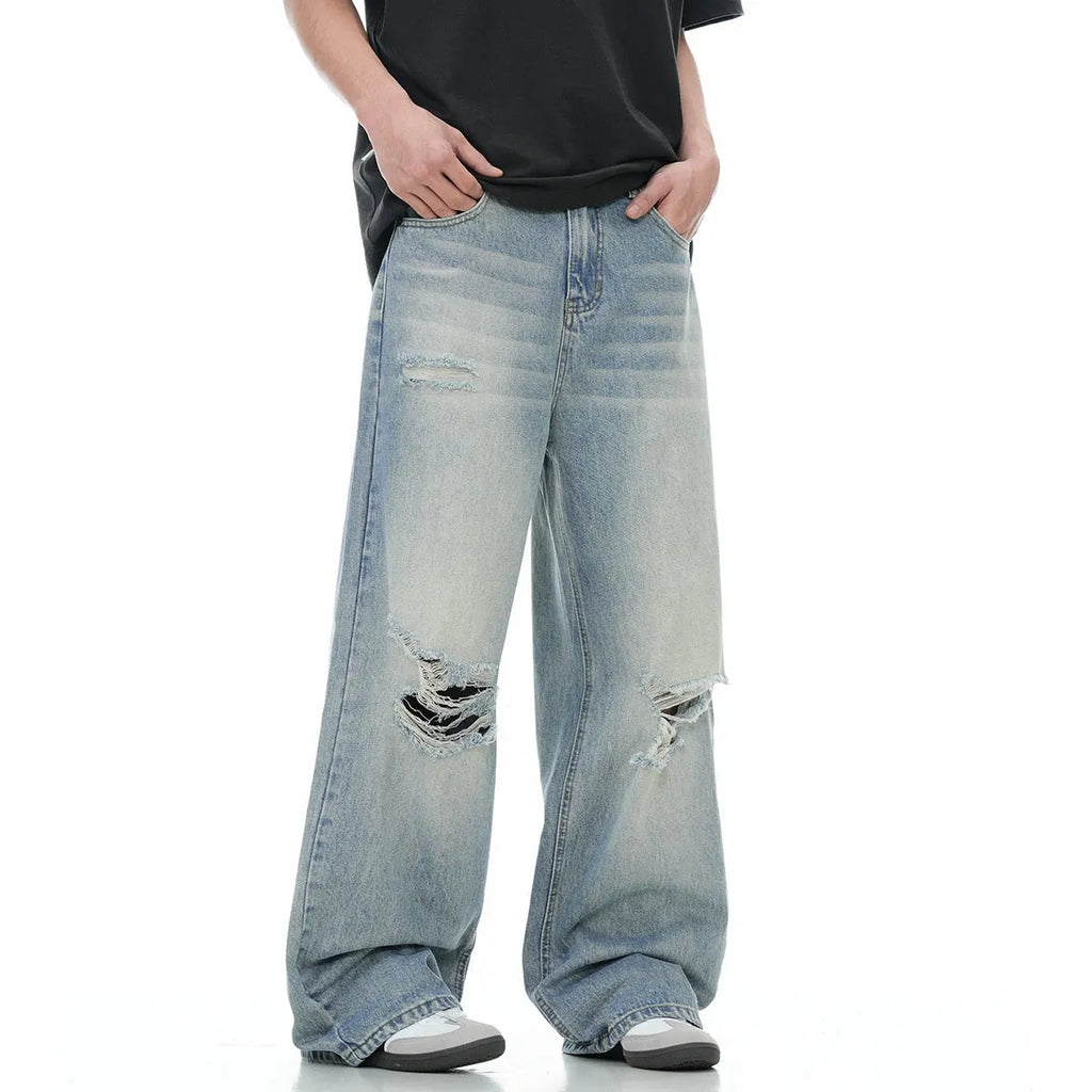 Blue men's straight-leg jeans with ripped detailing and a zip fly on a plain background.
