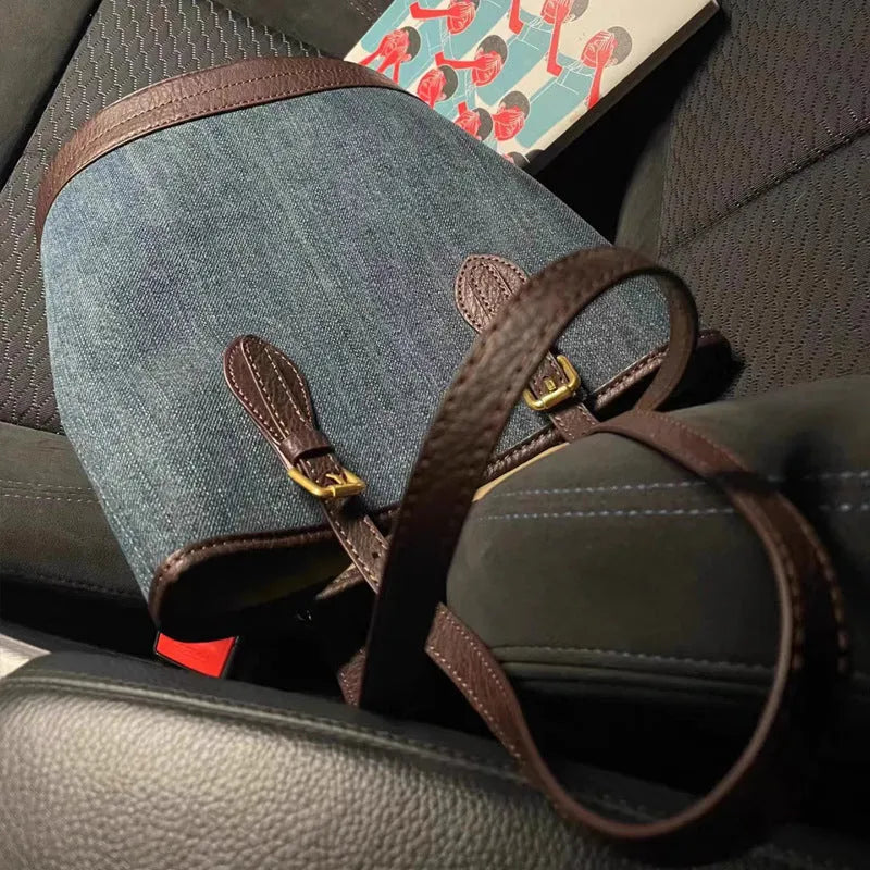 Denim wash patchwork one-shoulder bucket handbag showing front view and strap.