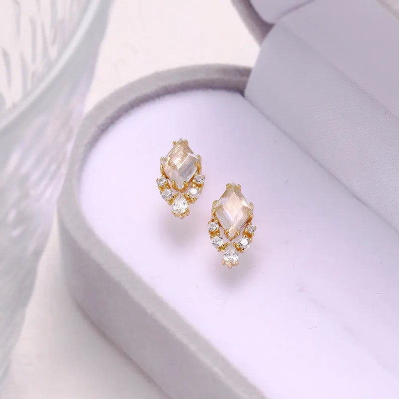Geometric 925 silver ear studs with natural white crystal accents on simple background