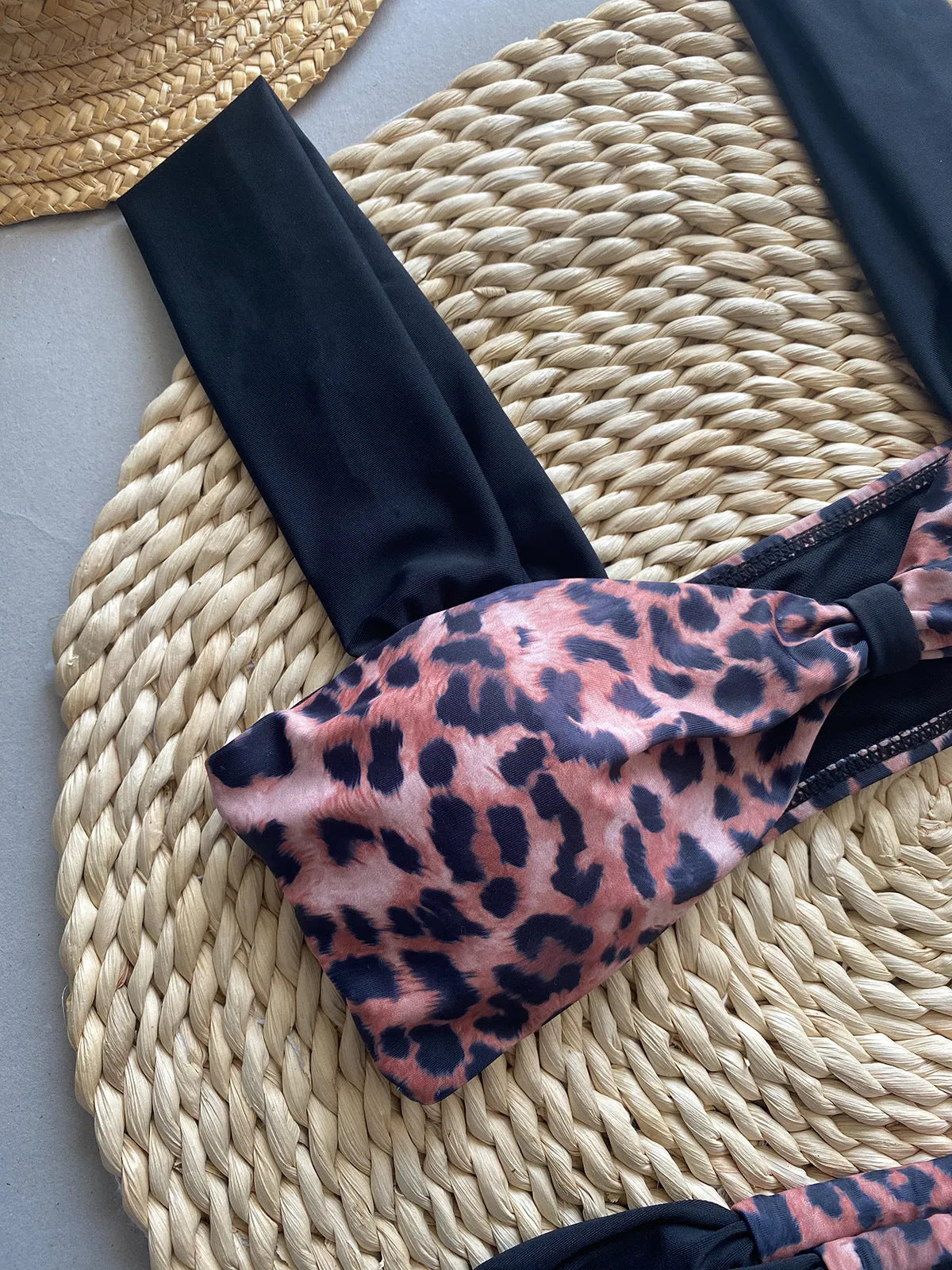 Women's leopard print bandeau bikini set with split top and T-pants bottoms.