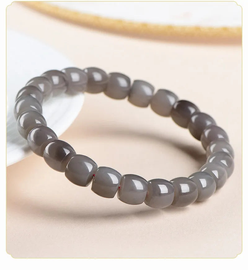Natural smokey violet Hetian jade straight cut bead bracelet on a wrist.