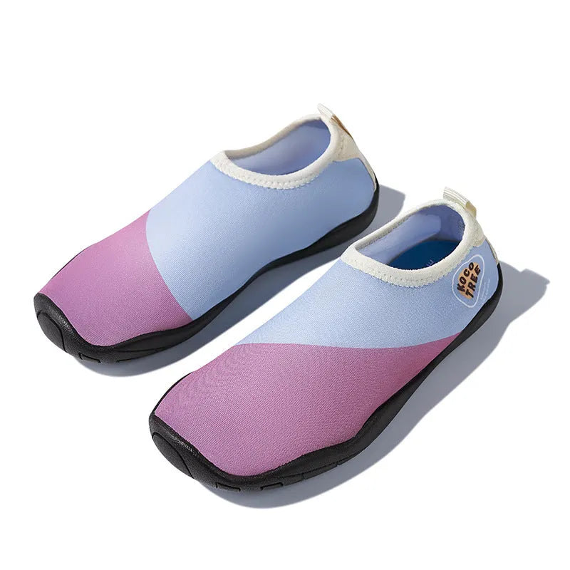 Children's anti-slip beach shoes in assorted colours with rubber soles and polyester fibre uppers.