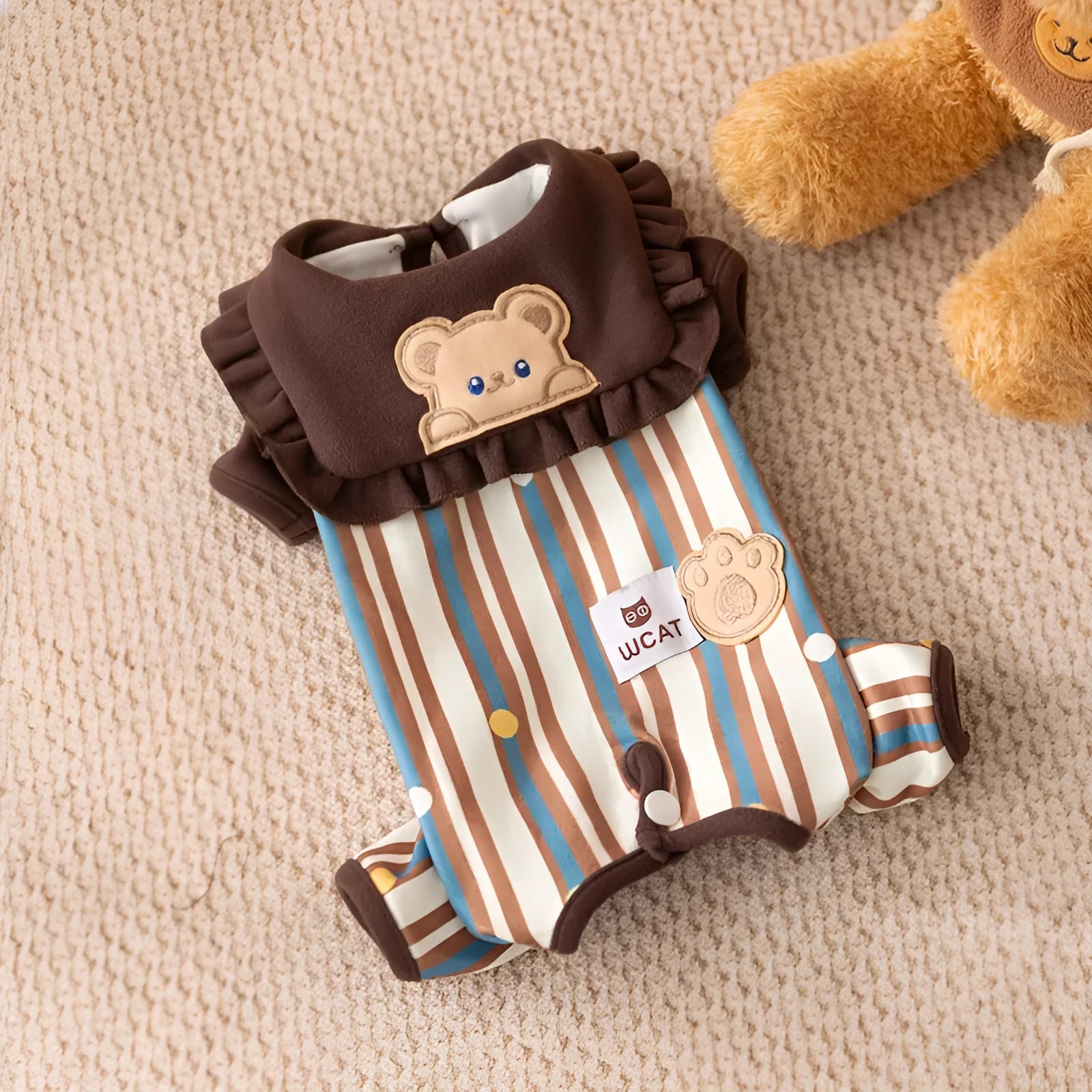 Brown small dog onesie with bear-embroidered ruffled collar, striped blue and brown body, and paw print patch