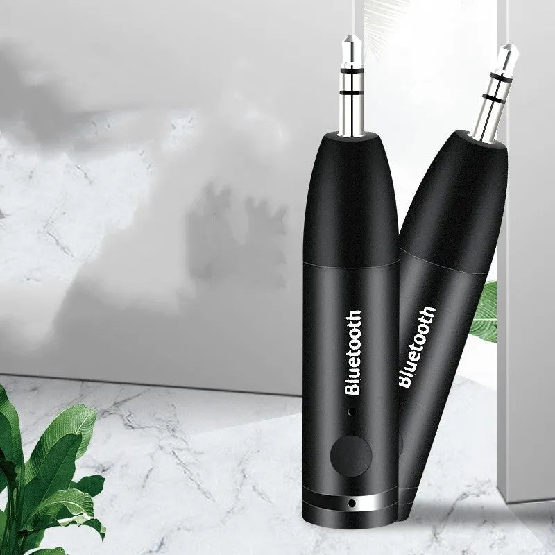 Black AUX Bluetooth 5.0 audio receiver for car or home stereo with USB cable.