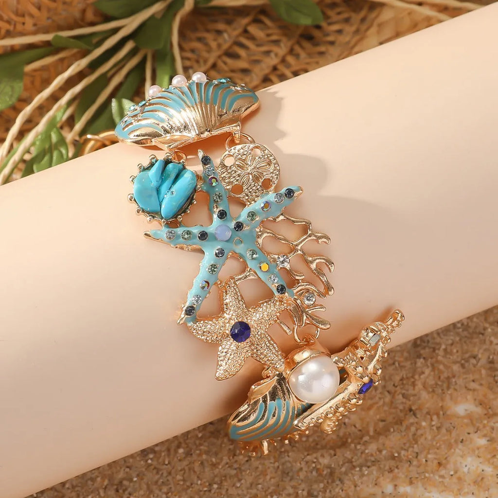 Women's alloy nautical bracelet with boat anchor, shell, and starfish charms in turquoise, red, or blue.
