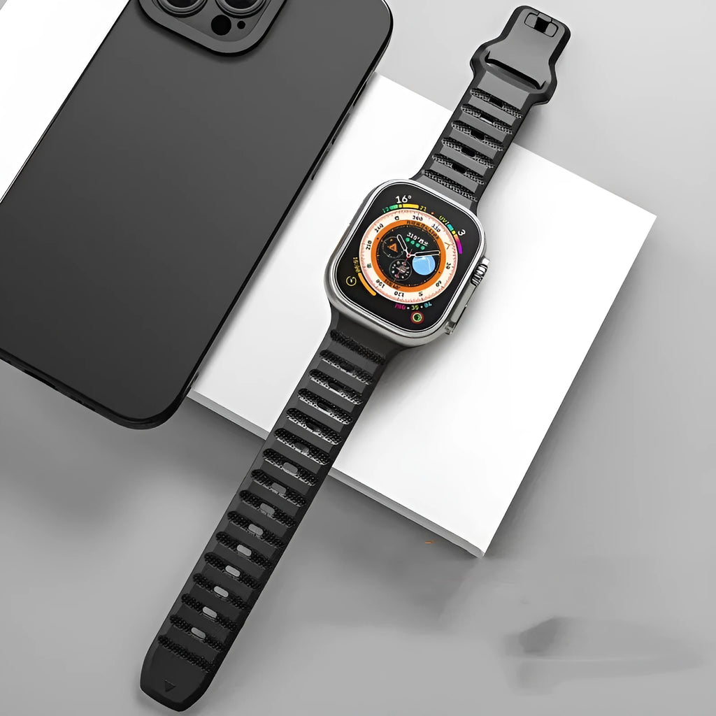 Fluoro rubber Apple Watch band with T-buckle in multiple colours on a grey background.
