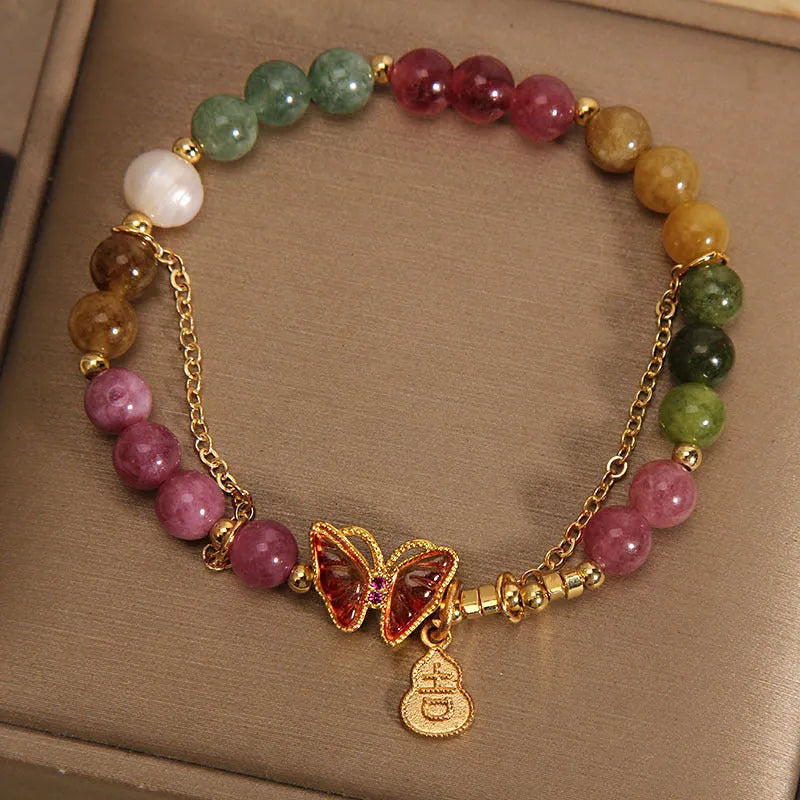 Natural jade coloured agate bracelet with a butterfly gourd tourmaline charm on an elasticated cord.