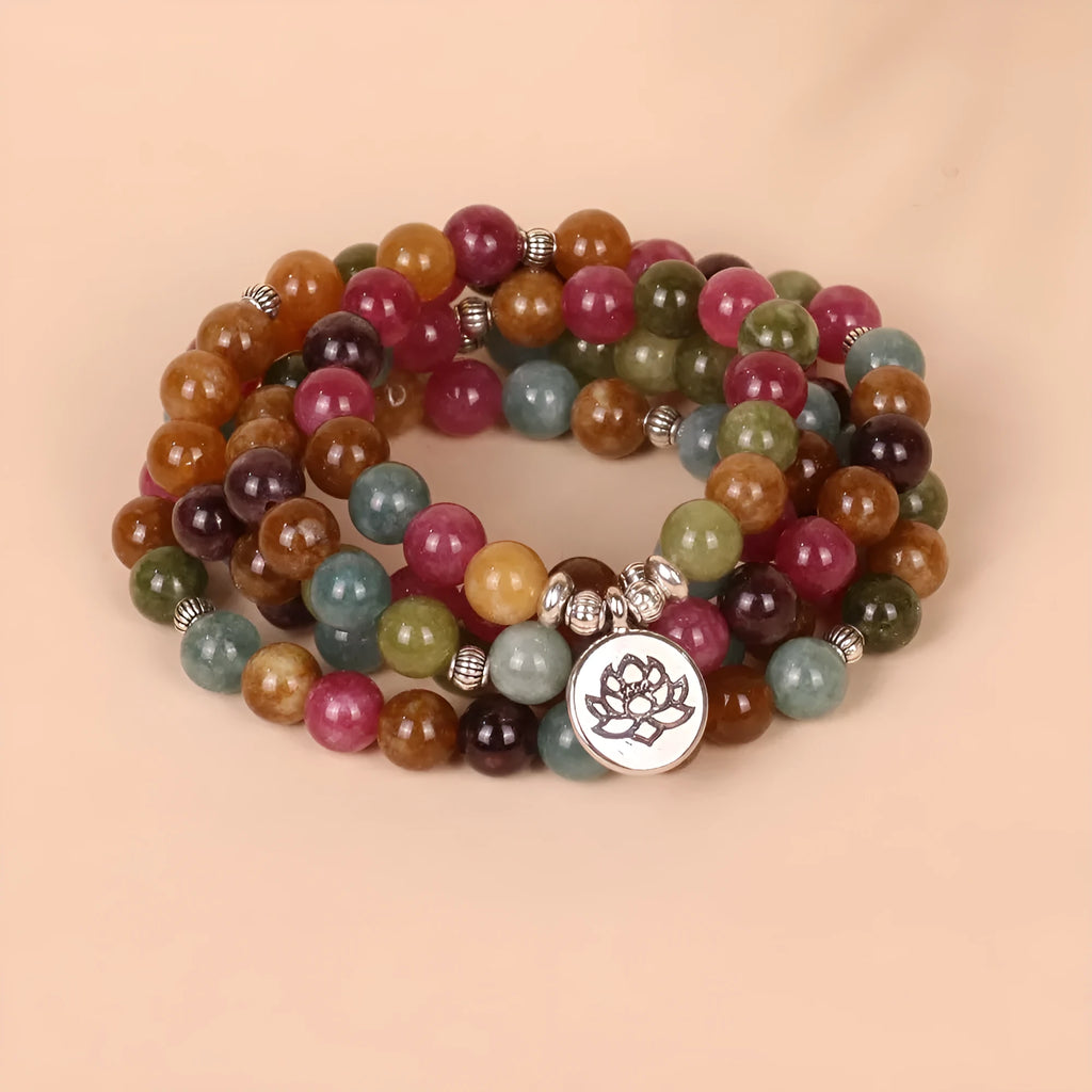 108 bead multi-layer bracelet in tourmaline colour with alloy details on a wrist.
