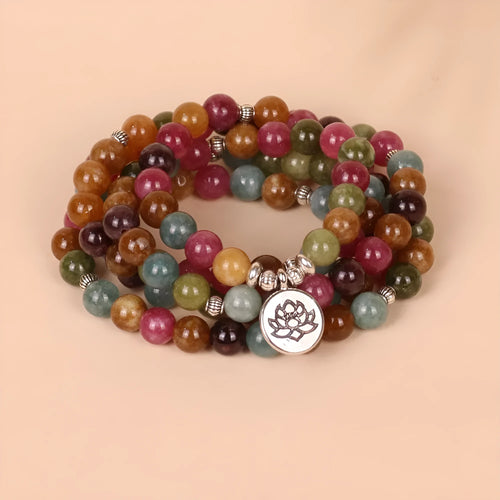 108 bead multi-layer bracelet in tourmaline colour with alloy details on a wrist.