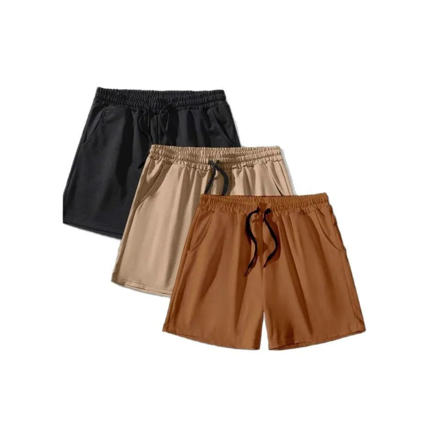 Three pairs of men's solid colour shorts with elastic drawstring waists in black, khaki and light brown