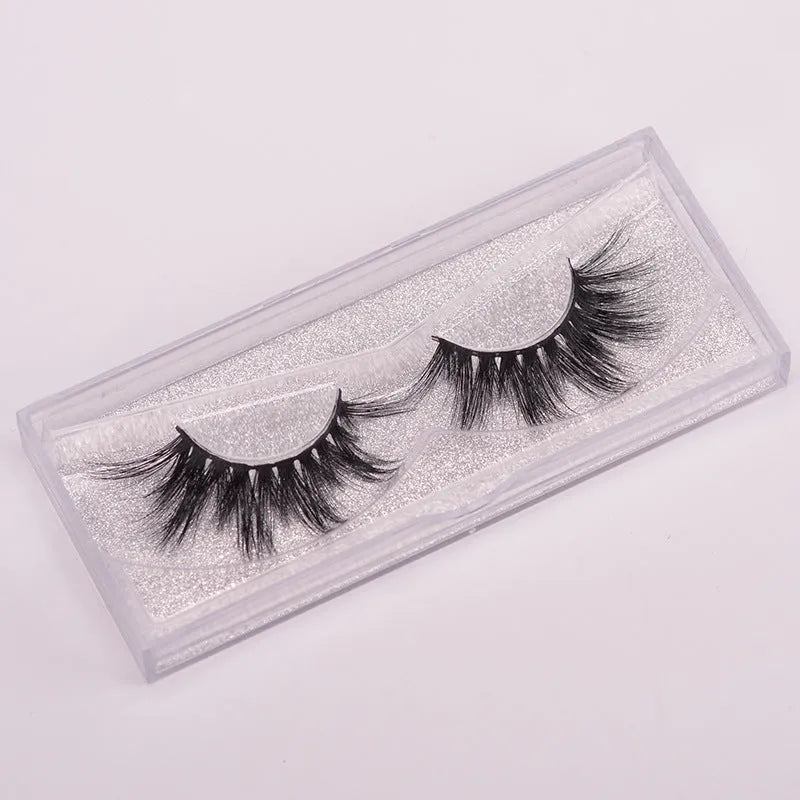 Hand-made 5D mink false eyelashes set with protective cap and dual-ended brush on a clean background