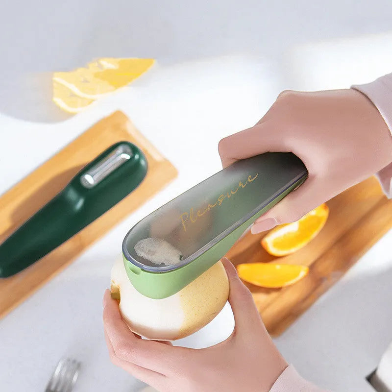 Dark green kitchen peeler with plastic handle inside its clear storage tube on a wooden surface.