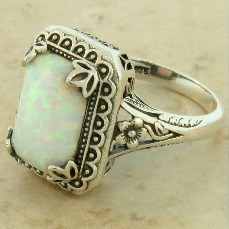 Silver alloy geometric ring with inlaid opal stone on a white background