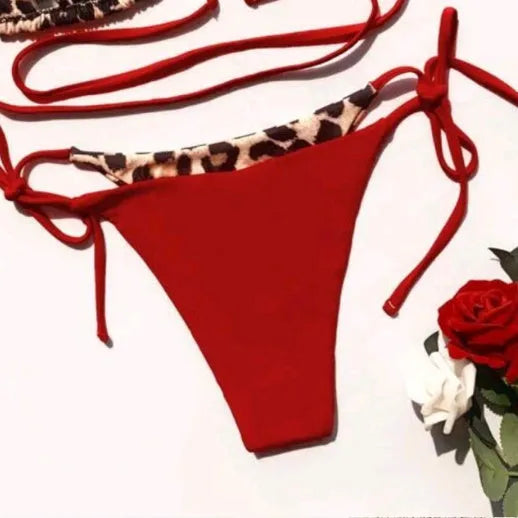Women's red leopard print bikini with halter neck lace-up top and high-waisted bottoms.