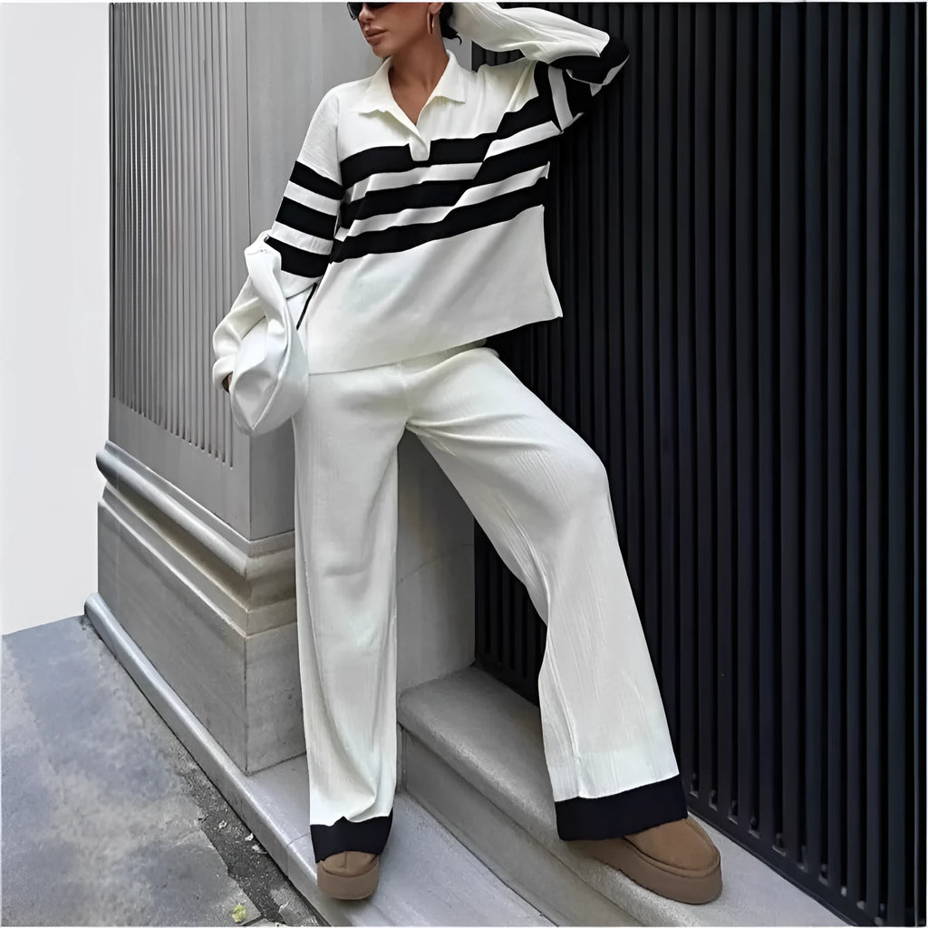 Women's black and white striped knitted two-piece set with polo collar top and straight-leg trousers laid flat.