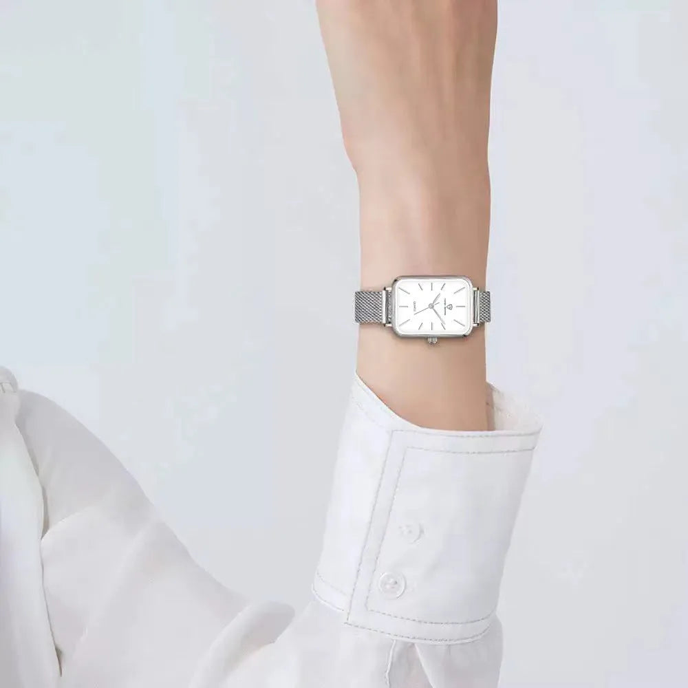 Rose gold women's quartz watch with woven steel strap on wrist, showing alloy case.