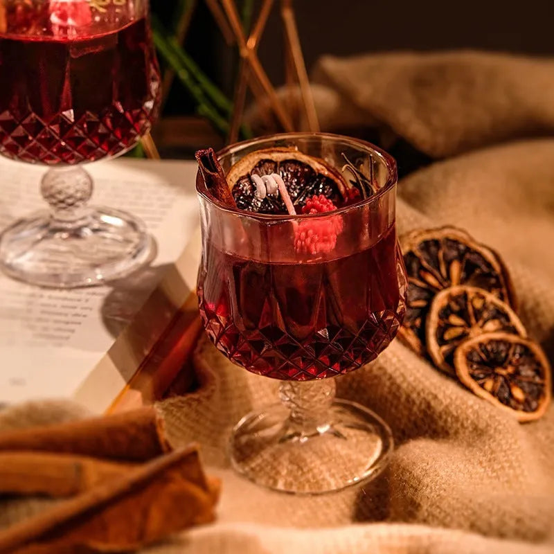 Glass wine goblet shaped container holding a French mulled wine scented aromatherapy candle.