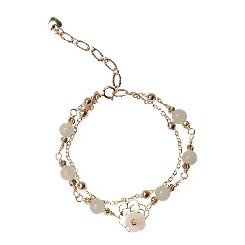 Yellow gold electroplated butterfly bracelet with shell flower design and Hetian jade accents on geometric copper jewellery