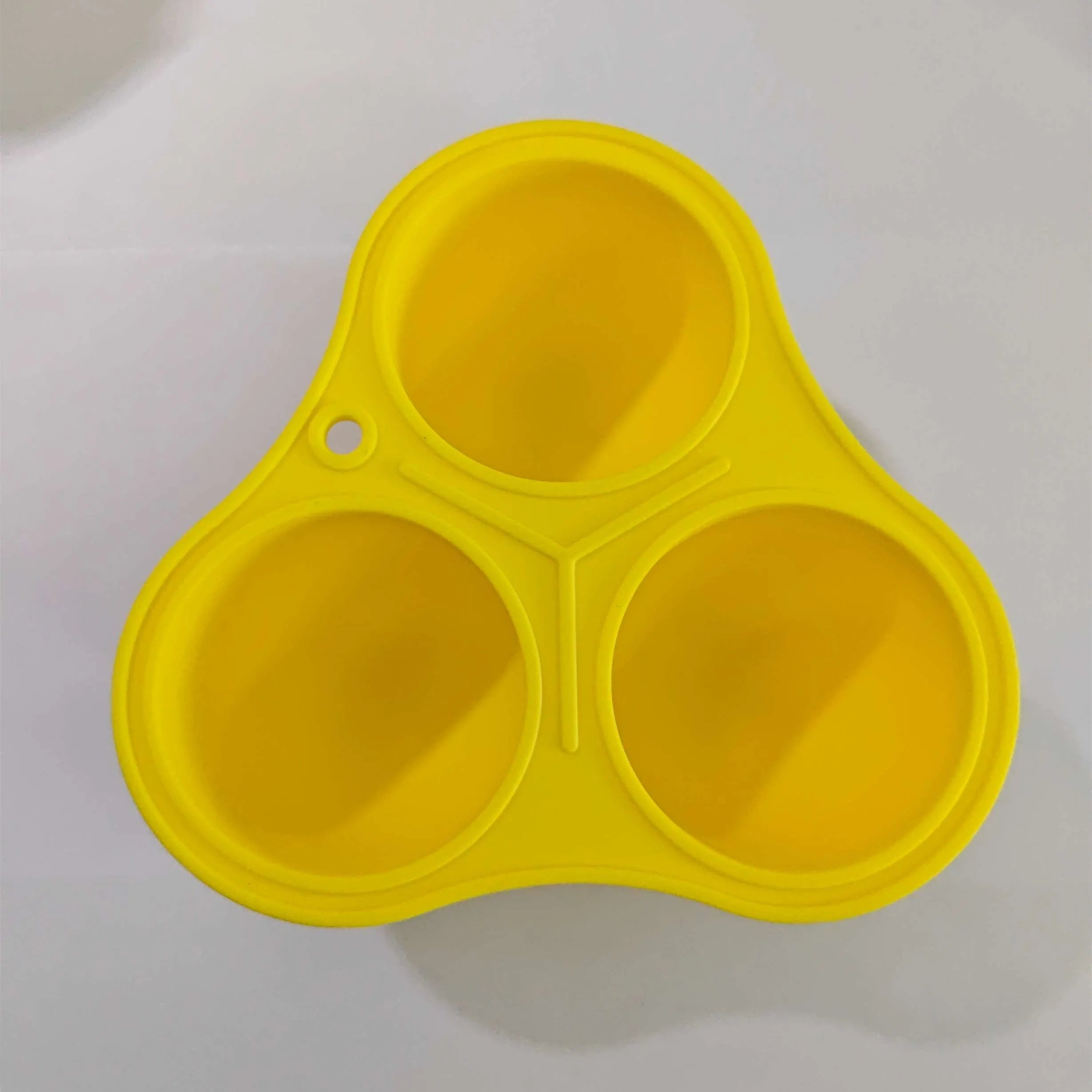 Yellow silicone pet dental ball with separate snack mould for treat dispensing and teeth cleaning
