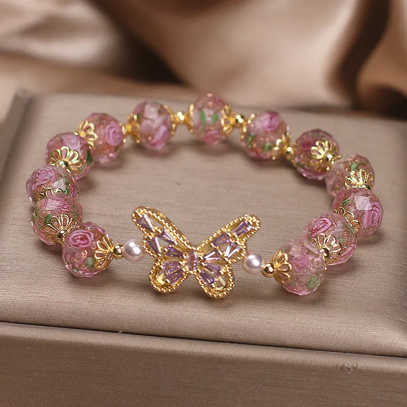 Pink crystal cherry blossom butterfly bracelet with hollow zircon accents on white background