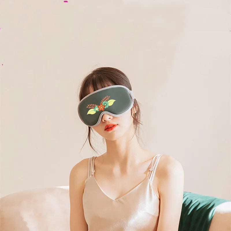 Pink portable eye steam massage goggles with USB cable on a grey background.