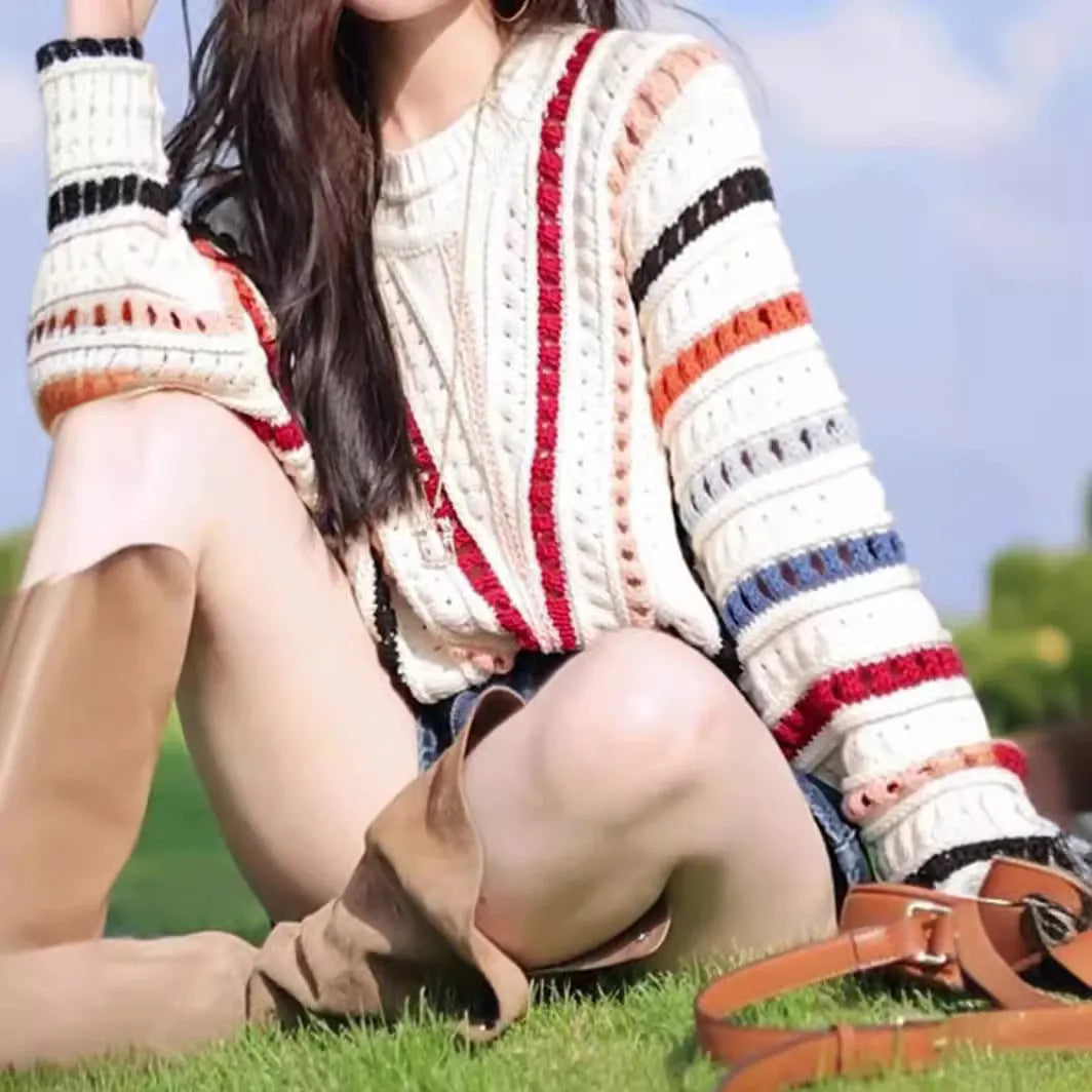 Retro rainbow striped loose fit sweater with batwing sleeves on a hanger.