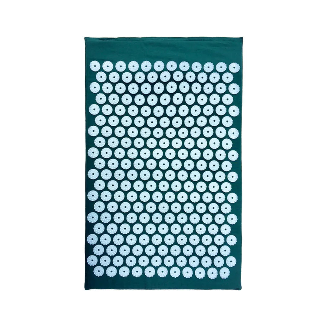 Black and blue acupuncture massage mat with cushion and headrest on floor
