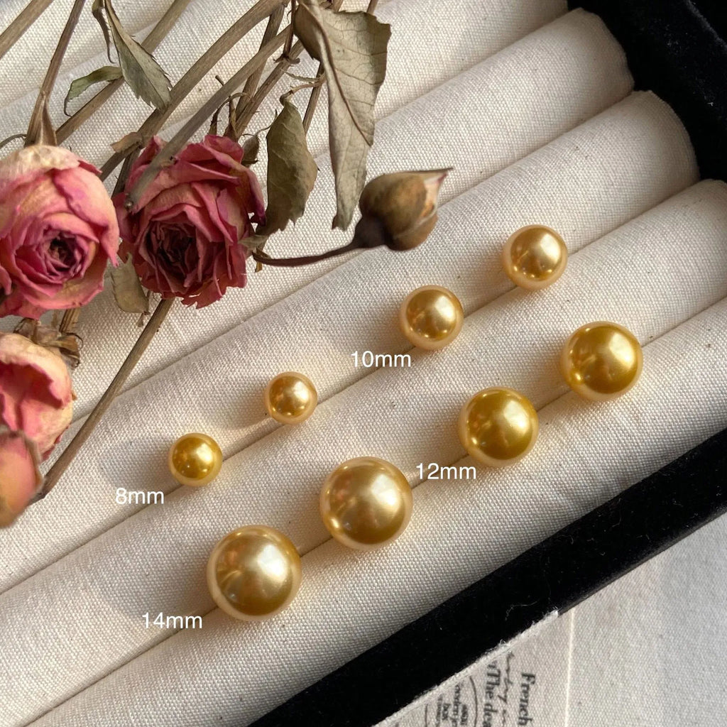 A pair of large geometric pearl stud earrings with a retro design on a silver setting.