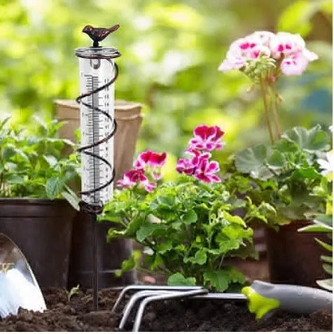 Cast iron outdoor garden rain gauge with hummingbird decoration and measurement scale.