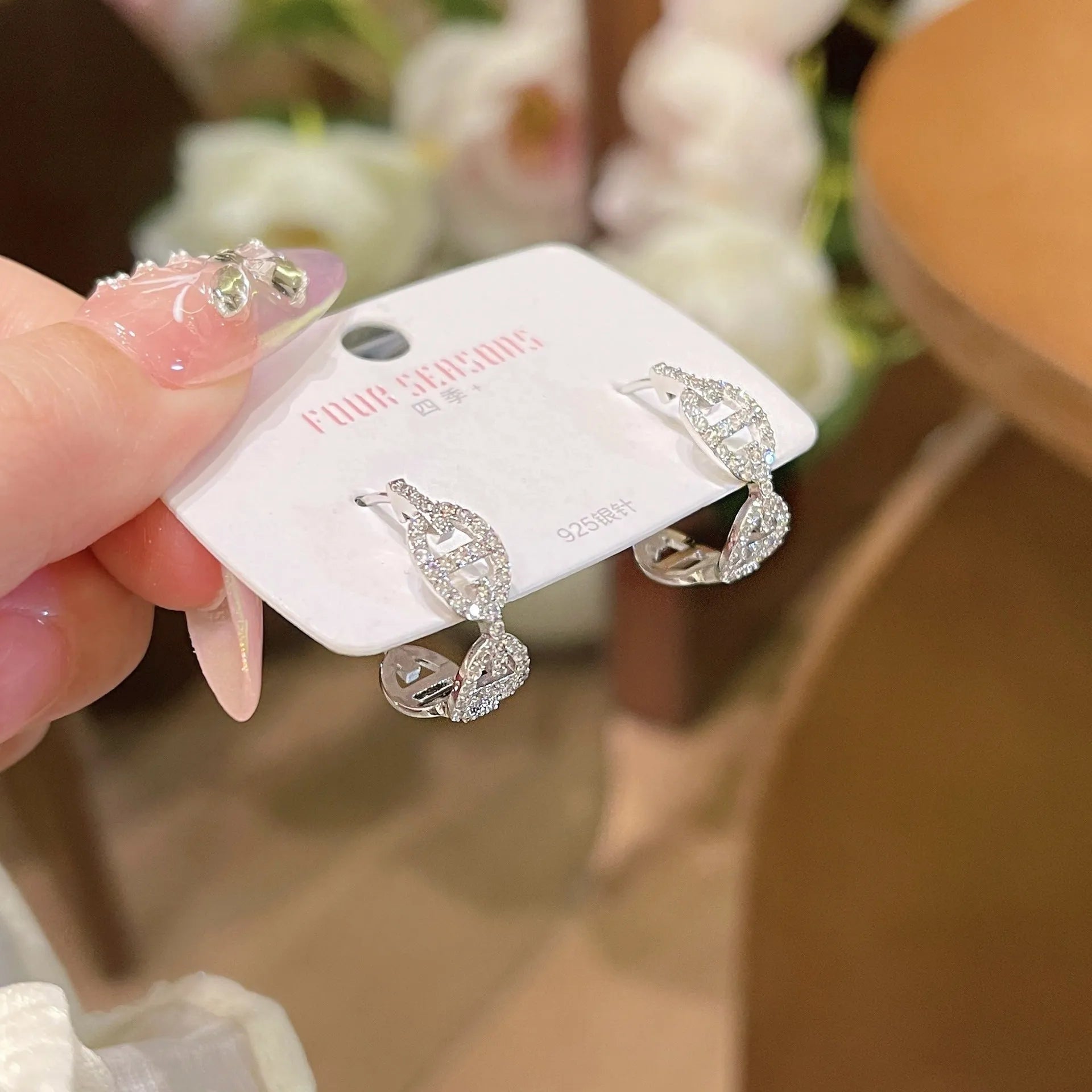 A pair of casual ladies earrings with a diamond-like detail, shown in an electroplated silver, gold, or rose gold finish.