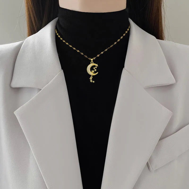Moon tassel necklace with full diamond geometric pendant on a stainless steel chain, showing tassel detail.