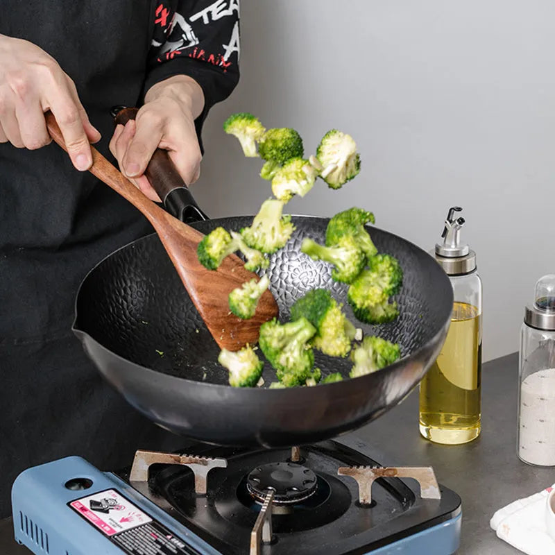 Black handmade iron wok with wooden handle, 32cm diameter.